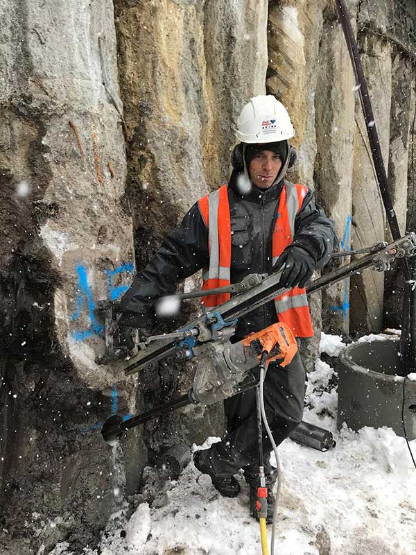 Homme travaillant la roche sous la neige